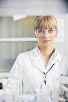 female researcher holding up a test tube in lab photo