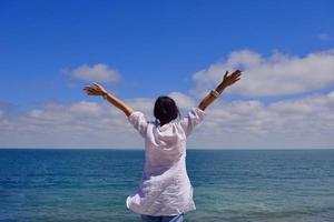 young woman with spreading arms to sky photo