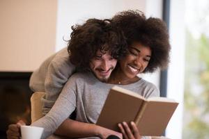 multiethnic couple hugging in front of fireplace photo