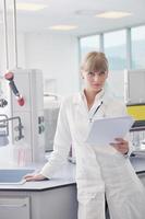 female researcher holding up a test tube in lab photo