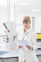 female researcher holding up a test tube in lab photo