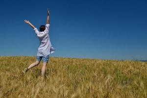 young woman in wheat field at summer photo