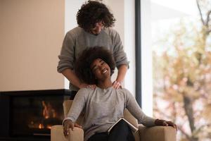 multiethnic couple hugging in front of fireplace photo