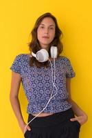 woman with headphones isolated on a yellow photo