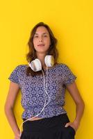 woman with headphones isolated on a yellow photo