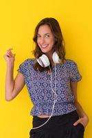 woman with headphones isolated on a yellow photo