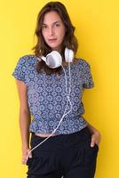 woman with headphones isolated on a yellow photo