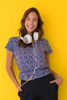 woman with headphones isolated on a yellow photo