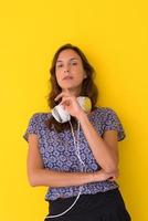 woman with headphones isolated on a yellow photo