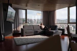 mujer usando tableta en hermoso apartamento foto