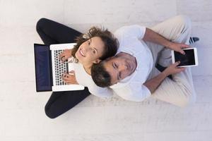 couple using tablet and laptop computers top view photo