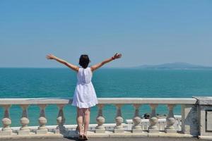 mujer joven feliz con los brazos extendidos al cielo foto