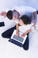 couple using tablet and laptop computers top view photo