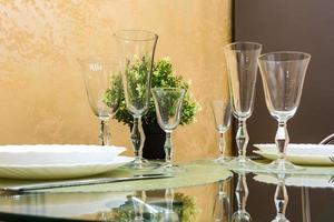 banquet table served with instruments and decorated with empty wine glasses photo