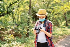 turistas jóvenes mujeres asiáticas turistas hermosas usan anteojos y sombreros en el bosque y ella revisa la foto mientras está de vacaciones en el bosque. viajes de aventura y concepto concepto de relajación de vacaciones.