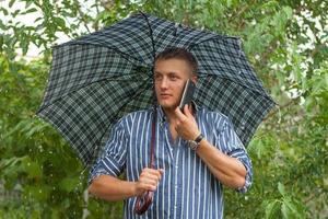 Man with umbrella and mobile phone photo