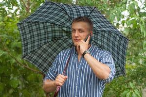 Man with umbrella and mobile phone photo