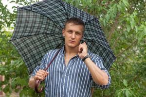 hombre con paraguas y teléfono móvil foto