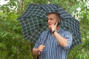 Man with umbrella and mobile phone photo