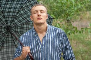 joven sexy mojado bajo la lluvia foto