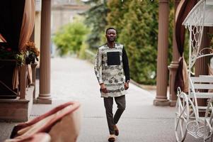 Handsome afro american man wearing traditional clothes in modern city. photo