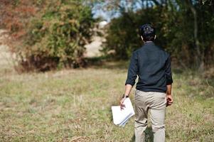 South asian agronomist farmer inspecting his farm. Agriculture production concept. photo