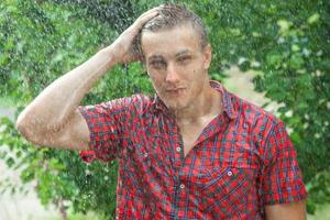 Sexy young man wet in rain photo