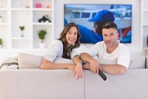 Young couple on the sofa watching television photo