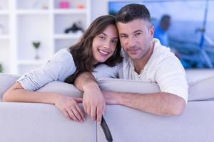 Young couple on the sofa watching television photo