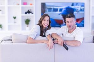 Young couple on the sofa watching television photo