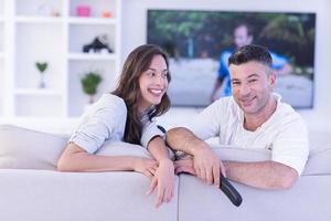 Young couple on the sofa watching television photo