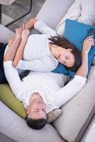 Young couple on the sofa watching television top view photo