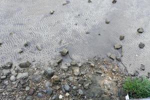 fondo de pila de pequeñas piedras en la arena foto