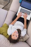 Young woman using laptop at home top view photo