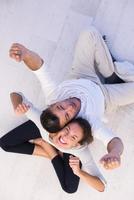 couple sitting with back to each other on floor photo