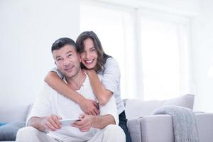 pareja feliz usando teléfono móvil en casa foto