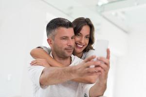 pareja feliz usando teléfono móvil en casa foto