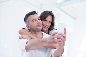 happy couple using mobile phone at home photo