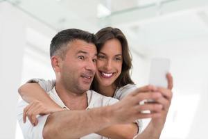 happy couple using mobile phone at home photo