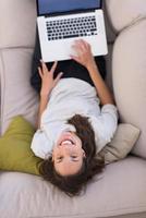 Young woman using laptop at home top view photo