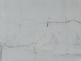 cracked damaged cement wall surface need of repair old background. affected by the earthquake photo