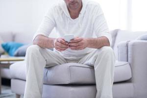 young man using a mobile phone  at home photo