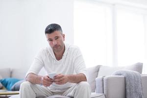 young man using a mobile phone  at home photo