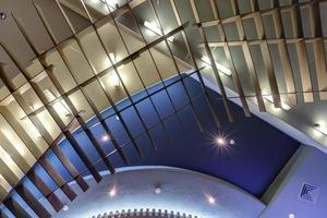 looking up on dark blue concrete ceiling with halogen spots in loft room with metal frame photo