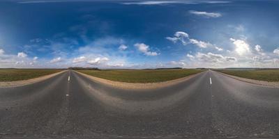 Panorama esférico completo sin costuras Vista angular de 360 grados en carretera asfaltada sin tráfico entre campos por la noche antes de la puesta del sol con cielo nublado. Panorama 360 en proyección equirrectangular, contenido vr ar foto