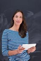 woman using tablet  in front of chalk drawing board photo