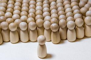 follow the leader or human resource management concept. crowd of wooden people photo