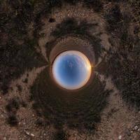 Inversion of little planet transformation of spherical panorama 360 degrees. Spherical abstract aerial view in field with awesome beautiful clouds. Curvature of space. photo