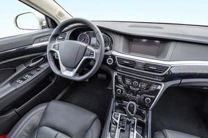 panorama en el interior del salón de cuero del coche moderno de prestigio. volante, palanca de cambios y salpicadero foto