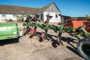 Parking agricultural machinery and harvest. rows of plows, cultivators, bodies photo